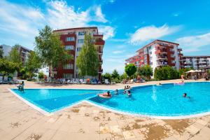 a swimming pool in a city with people in the water at Marina View Fort Beach in Sveti Vlas