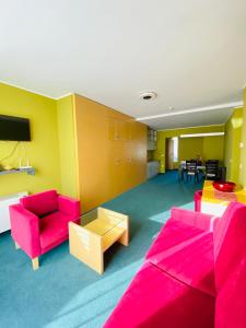 uma sala de estar com mobiliário rosa e uma mesa em Hotel Veter em Ruše