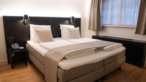 a bedroom with a large bed with white sheets and pillows at Corsendonk Hooge Heyde in Lichtaart