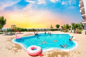 a pool at a resort with people in it at Marina View Fort Beach in Sveti Vlas