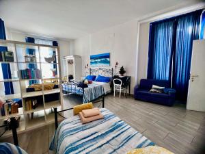 ein Schlafzimmer mit zwei Betten und einer Couch und einem Sessel in der Unterkunft Napoli Da Vivere Suites Giudecca in Neapel