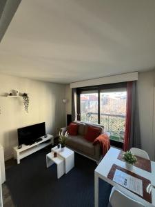 a living room with a couch and a tv at Le Jaude Centre studio in Clermont-Ferrand