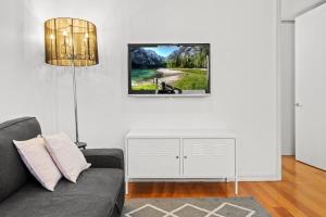 een woonkamer met een bank en een foto aan de muur bij Convenient Apartment in heart of Carlton in Melbourne