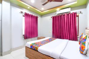 a bedroom with a bed and red curtains at FabHotel Stay Inn II in kolkata