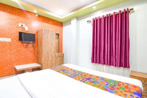 a bedroom with a bed and a tv in it at FabHotel Stay Inn II in kolkata