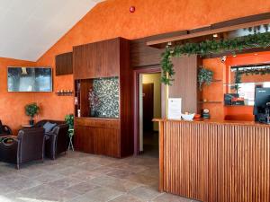 a lobby with an orange wall and a bar at Hotel Drangshlid in Skogar