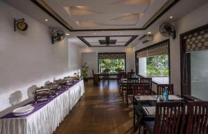 a dining room with tables and chairs in a restaurant at Nadhiyoram River Retreat in Cochin