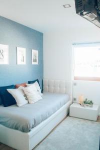 - un lit blanc dans une chambre avec fenêtre dans l'établissement Just Like Home - Moledo Shoreline, à Moledo