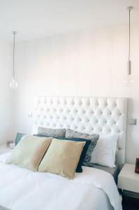 - un lit blanc avec une grande tête de lit et des oreillers blancs dans l'établissement Just Like Home - Moledo Shoreline, à Moledo