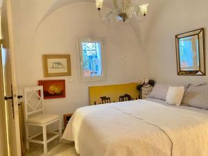 a bedroom with a white bed and a chair at Dar Zahra - Sidi Bou Said in Douar el Hafey