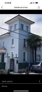 une photo d'une maison blanche avec une personne devant elle dans l'établissement Villa Rosa bella, à Poo de Llanes