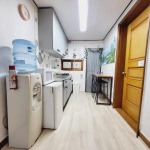 a kitchen with white appliances and a wooden door at Cozy Private Home Newly Renovated in Seoul