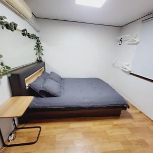 a small bedroom with a bed and a table at Cozy Private Home Newly Renovated in Seoul