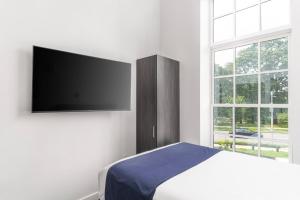 a bedroom with a bed and a flat screen tv at Stylish Studio in Historic Boston #207 in Boston