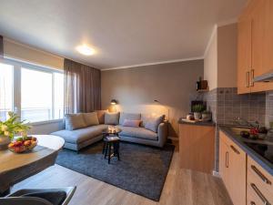 a living room with a couch and a table at Antares Spiekerooger Gästehaus-Sonnengartenbalkon West - Wohnung 6 in Spiekeroog