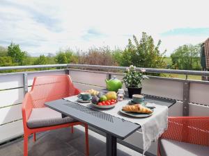a table and chairs on a balcony with food on it at Sonnengartenterrasse West - Wohnung 8 in Spiekeroog