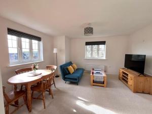 a living room with a dining table and a tv at Bright flat Chichester in Lavant