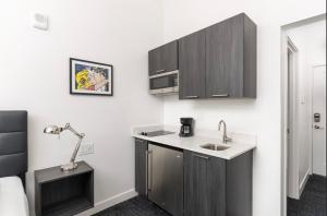 a small kitchen with a sink and a lamp at Stylish Studio in Historic Boston #208 in Boston