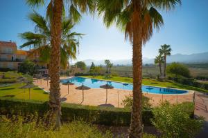 una gran piscina con sombrillas y palmeras en Sunstay House Sol Andalusi Alhaurin, en Alhaurín de la Torre 34 fotos más