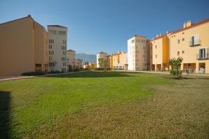 un grand champ herbeux devant certains bâtiments dans l'établissement Sunstay Casa de Sol Andalusi, à Alhaurín de la Torre