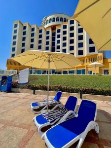 un groupe de chaises, un parapluie et un bâtiment dans l'établissement Oceanic Khorfakkan Resort & Spa, à Khor Fakkan
