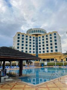 a hotel with a swimming pool in front of a building at Oceanic Khorfakkan Resort & Spa in Khor Fakkan