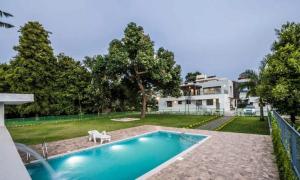 a house with a swimming pool in front of a house at Nadhiyoram River Retreat in Cochin
