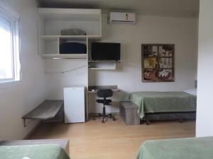 um quarto com 2 camas e uma secretária com um computador em Adoro Hotel em Farroupilha