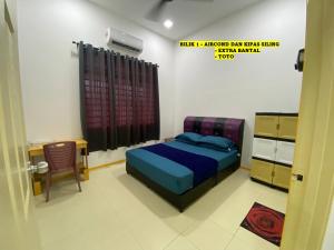 um quarto com uma cama, uma secretária e uma cadeira em Homestay Cikgu Ahmed Batu Kikir em Batu Kikir