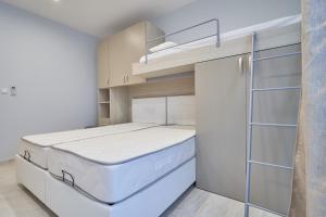 małą sypialnię z łóżkiem i szafą w obiekcie Comfort Lounge Loft - W/1BR w mieście Sliema