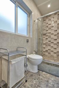 W łazience znajduje się toaleta i przeszklony prysznic. w obiekcie Comfort Lounge Loft - W/1BR w mieście Sliema