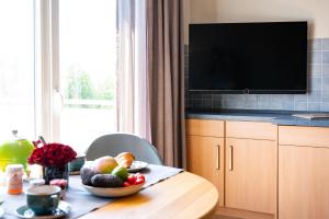 a kitchen with a table with a bowl of fruit on it at Antares Spiekerooger Gästehaus-Sonnengartenbalkon Nord - Wohnung 5 in Spiekeroog