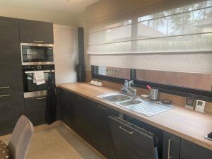 a kitchen with a sink and a microwave and a window at Villa Maclo Hardelot in Neufchâtel-Hardelot