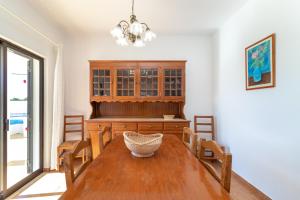 uma sala de jantar com uma mesa de madeira e cadeiras em Casa Prensa em Carvoeiro