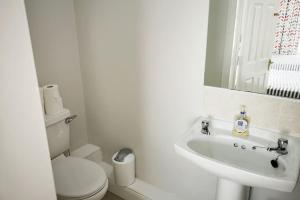 biała łazienka z toaletą i umywalką w obiekcie The Sandhills, Tramore Beach w mieście Tramore