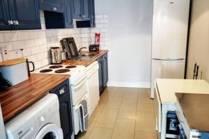 a kitchen with a white stove top oven next to a refrigerator at The Sandhills, Tramore Beach in Tramore