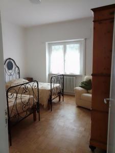 a bedroom with a bed and a couch and a window at villa gesualda in Bagno di Romagna