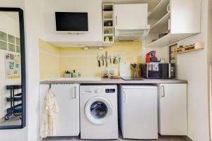 uma lavandaria com máquina de lavar e secar roupa em Studio calme proche Paris avec terrasse privative et jacuzzi en option em Palaiseau