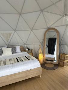 Habitación con cama y espejo en una yurta en Moon Camp Khaoyai, en Ban Nong Song Hong