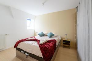 - une petite chambre avec un lit et une couverture rouge dans l'établissement Urban Balcony - Avec parking à Villiers-sur-Marne, à Villiers-sur-Marne