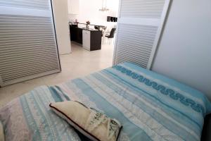 a bedroom with a bed and a hallway with a kitchen at Casa del sur in San Juan de los Terreros +36 photos