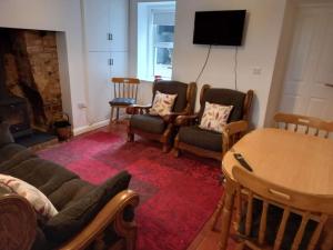 a living room with a table and chairs and a fireplace at Bramble Cottage in Dungannon