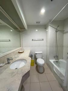 Golden Peak Hotel & Suites powered by Cocotel في مدينة سيبو: حمام مع حوض ومرحاض وحوض استحمام