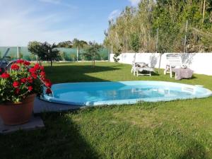 Una piscina en un patio con flores en el césped. en Casa Salitre, en Boiro