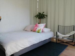 - une chambre avec un lit doté d'oreillers et d'une chaise dans l'établissement Casa Salitre, à Boiro