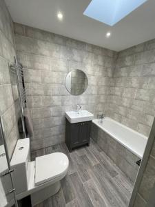 a bathroom with a sink and a tub and a toilet at Holyhead central stay in Holyhead