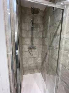 y baño con ducha y puerta de cristal. en Holyhead central stay, en Holyhead