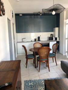a kitchen with a table and chairs in a room at Votre oasis de détente : Appartement flambant neuf, 1 chambre, 4 couchages à Aubigné-racan in Aubigné-Racan +4 photos