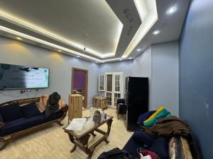 a living room with a couch and a tv at بالقرب من مدينتي شقه مميزه جديده ثلاث غرف وحمامين in Badr