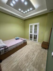 a bedroom with a bed in a room with green walls at بالقرب من مدينتي شقه مميزه جديده ثلاث غرف وحمامين in Badr